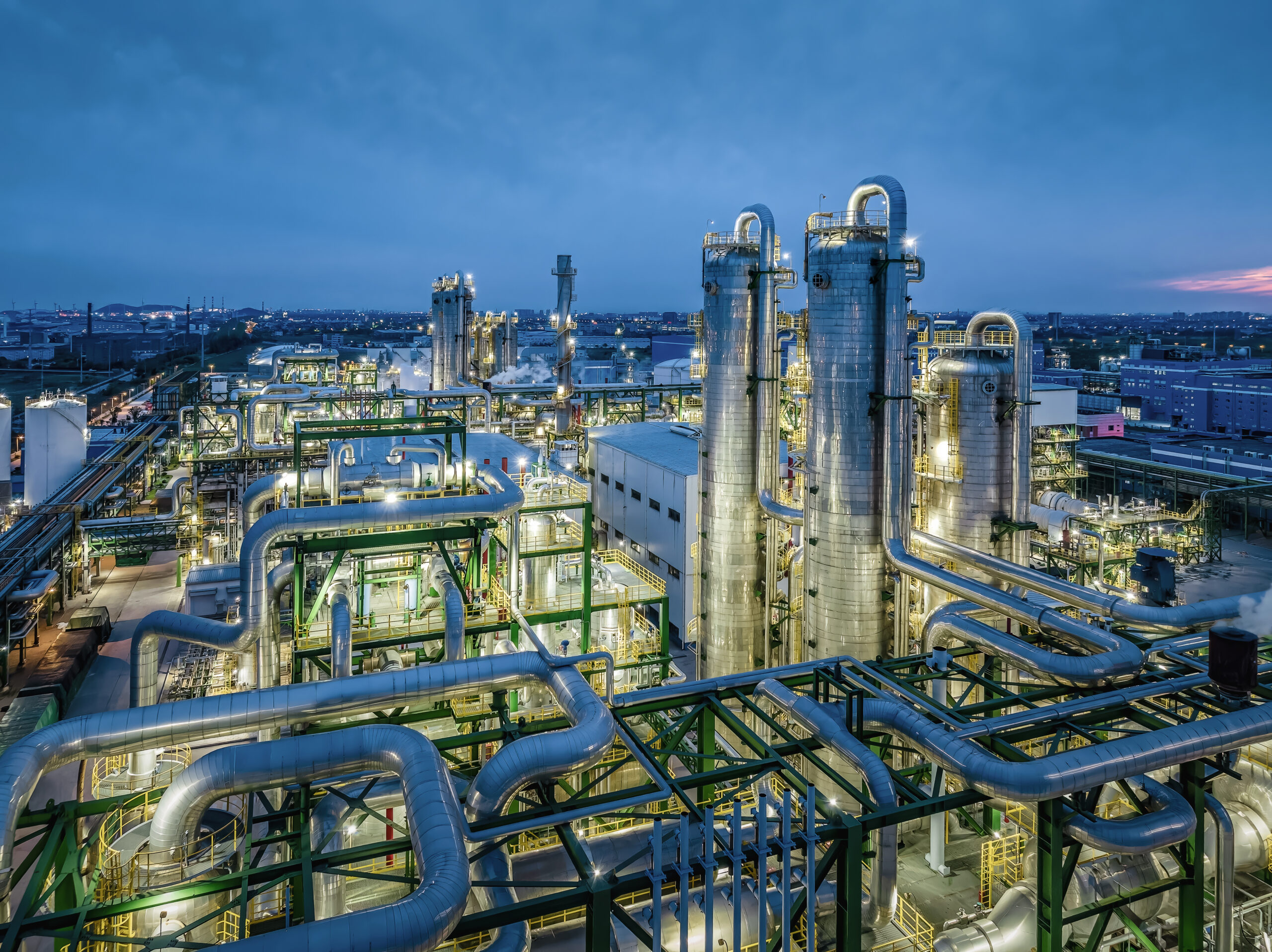 Oil refinery chemical plant industrial equipment buildings at night